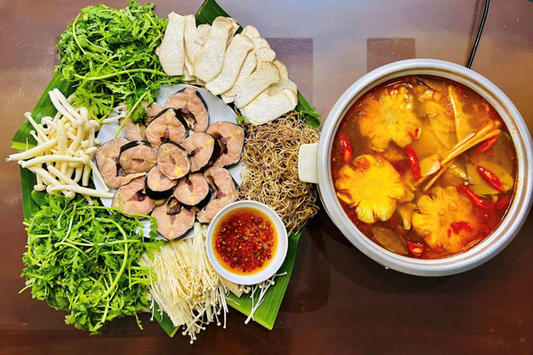 Lẩu cá tầm với rau xanh và các món ăn kèm
